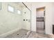 Contemporary bathroom featuring a glass-enclosed shower and a peek into the closet at 17336 W Crawfordsville Dr, Surprise, AZ 85388