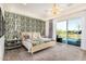 Bright bedroom featuring a king bed, chandelier, and sliding doors with a view of the pool at 17336 W Crawfordsville Dr, Surprise, AZ 85388