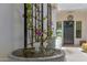 Close-up of a courtyard fountain with purple flowering vines covering the adjacent courtyard wall at 17336 W Crawfordsville Dr, Surprise, AZ 85388