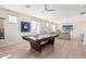 Bright game room with a pool table, sectional sofa, modern ceiling fan, and views of the neighborhood at 17336 W Crawfordsville Dr, Surprise, AZ 85388