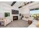 Comfortable living room featuring a fireplace, stylish decor, and large windows providing ample natural light at 17336 W Crawfordsville Dr, Surprise, AZ 85388