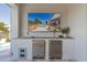 Outdoor bar features a beer tap and a TV showing the backyard pool and seating area at 17336 W Crawfordsville Dr, Surprise, AZ 85388