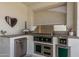 Well-equipped outdoor kitchen featuring stainless steel appliances, custom cabinetry, and stone countertops at 17336 W Crawfordsville Dr, Surprise, AZ 85388