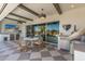 Expansive outdoor patio with dining area, outdoor kitchen, and tv with view of the backyard at 17336 W Crawfordsville Dr, Surprise, AZ 85388