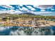 Beautiful aerial view of a lake with picnic ramadas, a beach area, and palm trees surrounded by mountains under a sunny sky at 17563 W Summit Dr, Goodyear, AZ 85338