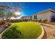 Lush backyard featuring artificial grass, desert landscaping, and a stone-lined border at 17563 W Summit Dr, Goodyear, AZ 85338