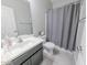 Clean bathroom features a single vanity, a shower with grey shower curtain, and neutral tones at 17563 W Summit Dr, Goodyear, AZ 85338