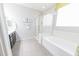 Modern bathroom featuring a soaking tub, glass-enclosed shower, and neutral color palette at 17563 W Summit Dr, Goodyear, AZ 85338