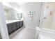 Bathroom with dual sinks, black cabinets, a glass-enclosed shower, and modern fixtures at 17563 W Summit Dr, Goodyear, AZ 85338