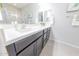 Bathroom featuring a double sink vanity with dark cabinets, ample counter space, and contemporary design at 17563 W Summit Dr, Goodyear, AZ 85338