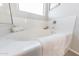 Bright bathroom featuring a soaking tub, a shower with glass door, and white tile at 17563 W Summit Dr, Goodyear, AZ 85338
