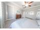 Bedroom featuring a ceiling fan, tray ceiling, wood dresser, and neutral paint at 17563 W Summit Dr, Goodyear, AZ 85338