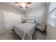 Neat bedroom includes a plush bed, ceiling fan, and a charming bedside lamp with ample closet space at 17563 W Summit Dr, Goodyear, AZ 85338