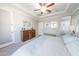 Bedroom featuring a ceiling fan, tray ceiling, wood dresser, and neutral paint at 17563 W Summit Dr, Goodyear, AZ 85338