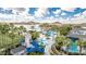 Aerial view of the community pool area featuring a waterslide, splash pad, and palm trees with a scenic lake backdrop at 17563 W Summit Dr, Goodyear, AZ 85338