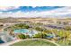 Aerial view of the community pool, recreational area and neighborhood retail, with a backdrop of mountains on a sunny day at 17563 W Summit Dr, Goodyear, AZ 85338