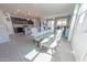 Open dining area with glass table, upholstered chairs, and views of the kitchen and living room at 17563 W Summit Dr, Goodyear, AZ 85338