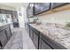 Close-up of kitchen featuring dark cabinets, granite countertops, and stainless steel appliances at 17563 W Summit Dr, Goodyear, AZ 85338