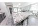 Kitchen island with granite countertop and barstools opens to the living area at 17563 W Summit Dr, Goodyear, AZ 85338