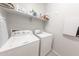 Well-equipped laundry room features a washer, dryer, shelf space, and essential laundry supplies at 17563 W Summit Dr, Goodyear, AZ 85338