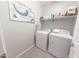 Practical laundry room equipped with modern washer and dryer units, shelving and clean and fresh signage at 17563 W Summit Dr, Goodyear, AZ 85338