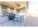 The covered patio area features a ceiling fan, dining table set, grill, and ample room at 17563 W Summit Dr, Goodyear, AZ 85338