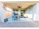 Covered patio includes a ceiling fan, dining table set, grill, and outdoor seating at 17563 W Summit Dr, Goodyear, AZ 85338
