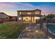 Beautiful backyard with a covered patio and a swimming pool under a colorful sunset sky at 1835 E Bartlett Pl, Chandler, AZ 85249