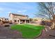 Spacious backyard showcasing a green lawn, covered patio with seating, and mature landscaping, creating a serene outdoor space at 1835 E Bartlett Pl, Chandler, AZ 85249