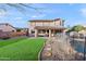 This backyard boasts a lush lawn, a covered patio, stepping stones, and a sparkling pool for the ultimate outdoor oasis at 1835 E Bartlett Pl, Chandler, AZ 85249