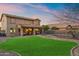 Large backyard features a manicured lawn, covered patio, and a fenced pool with a rock feature, great for outdoor enjoyment at 1835 E Bartlett Pl, Chandler, AZ 85249