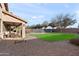 Large backyard featuring a well-manicured lawn, a covered patio with comfortable seating, and mature trees at 1835 E Bartlett Pl, Chandler, AZ 85249