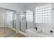 Bathroom featuring a walk-in glass shower and tub with tile walls at 1835 E Bartlett Pl, Chandler, AZ 85249