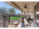 Relaxing covered patio featuring comfortable seating, ceiling fans, and string lights, overlooking a well-maintained backyard and pool at 1835 E Bartlett Pl, Chandler, AZ 85249