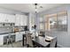 Bright dining area featuring a modern light fixture, wood flooring, and a large window overlooking the yard at 1835 E Bartlett Pl, Chandler, AZ 85249