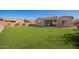 A wide view of the artificial grass and covered patio in this home's backyard at 18406 W Verbena Dr, Goodyear, AZ 85338