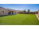This spacious backyard features artificial grass and a covered patio at 18406 W Verbena Dr, Goodyear, AZ 85338
