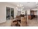 Bright dining area with backyard access, stylish light fixture, and an open layout to the kitchen at 18406 W Verbena Dr, Goodyear, AZ 85338