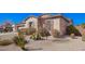 Close up of desert landscaped yard featuring a tan stucco exterior and shuttered windows at 18406 W Verbena Dr, Goodyear, AZ 85338