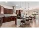 This gourmet kitchen boasts dark wood cabinetry, granite countertops, stainless appliances, and a cozy breakfast nook at 18406 W Verbena Dr, Goodyear, AZ 85338