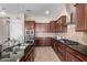 Gourmet kitchen with granite countertops, stainless steel appliances, and dark wood cabinets at 18406 W Verbena Dr, Goodyear, AZ 85338