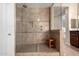 Modern walk-in shower features dual shower heads, built-in niche, and a convenient wooden bench at 18406 W Verbena Dr, Goodyear, AZ 85338