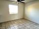 Bedroom featuring tile flooring, neutral walls, a ceiling fan, and a bright window with natural light at 1859 E 8Th St, Mesa, AZ 85203