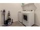 Bright laundry room with washer, dryer, tiled floor, shelving, and cleaning supplies at 1941 W Trotter Trl, Phoenix, AZ 85085