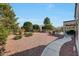 Low-maintenance backyard featuring a covered patio, walkway, and lush desert landscaping at 20049 N Siesta Rock Dr, Surprise, AZ 85374