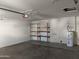 Spacious garage featuring a water heater, shelving, and concrete flooring at 2051 W Ronald Rd, Phoenix, AZ 85029