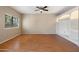 Bright living room featuring wood flooring, a ceiling fan, and a built in shelving unit at 2051 W Ronald Rd, Phoenix, AZ 85029
