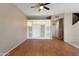 Open living room with ceiling fan, wood flooring, and built in shelving provides ample storage space at 2051 W Ronald Rd, Phoenix, AZ 85029