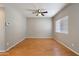 Spacious living room featuring wood floors, ceiling fan, and natural light from the window at 2051 W Ronald Rd, Phoenix, AZ 85029
