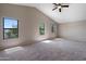 Vaulted main bedroom with three windows, plush carpet, and ceiling fan at 2051 W Ronald Rd, Phoenix, AZ 85029